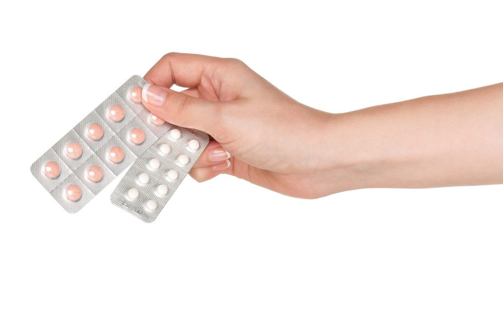 Pills in woman hand isolated on white background