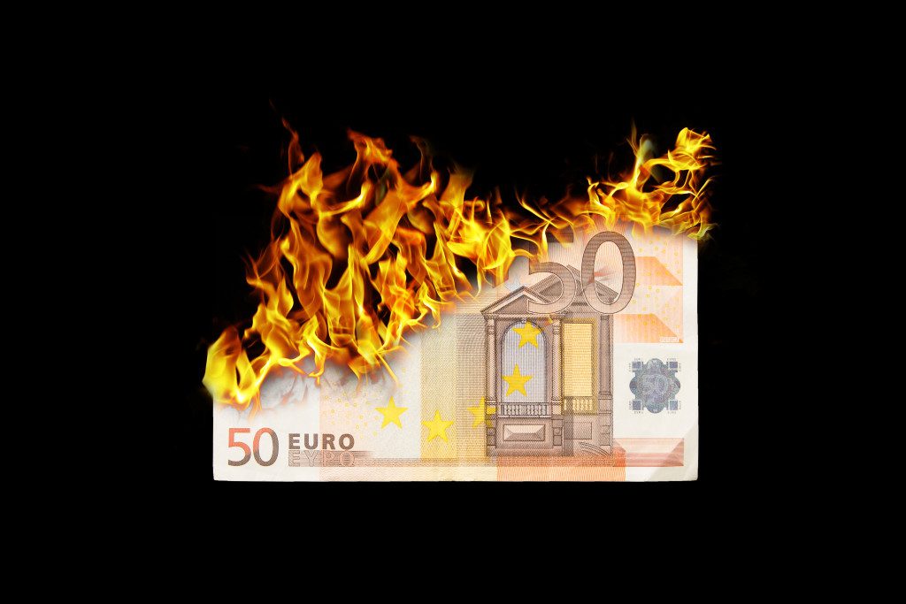 Burning money, euro bill on fire, isolated on black